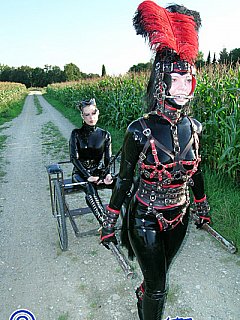 Ponygirl is wearing shiny latex costume for an outdoor ride