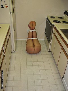 Bondage on a kitchen: tied up lady wearing just bra and pantyhose