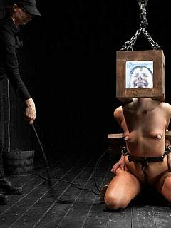 Bondage girl is having her head boxed and there is a chain crotch rope is put deeply in between her pussy cheeks