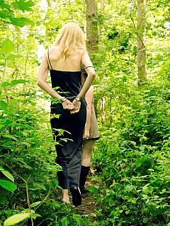 Mistress is walking the handcuffed subgirl on a chain while in the woods