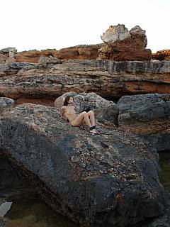 Naked subgirl is trained in the rocks: girl is kneeling with her head put underwater