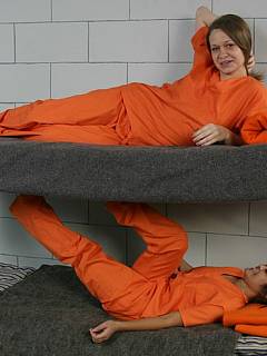 One sexy prisoner punishes another by spanking and fingering her ass