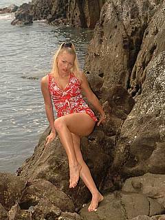 Tied up blonde looks very vulnerable once left almost naked on the sharp rocks at the sea shore