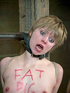 Slavegirl with degrading body captions on her chest is becoming strangled with the leather belt