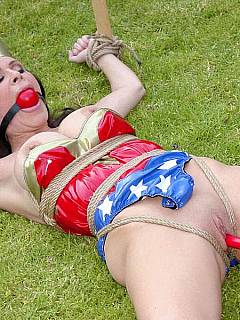 Wonder Woman is cativated, left tied spread eagle on the lawn and there is a bomb shoved into her pussy. The fuse is burning!