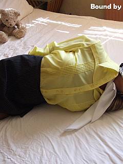 Yet anopther sexy woman is hogtied on the bed while dressed in her everyday clothes