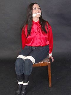 Fully clothed woman in bondage: wearing jeans, gagged and blindfolded with cloth