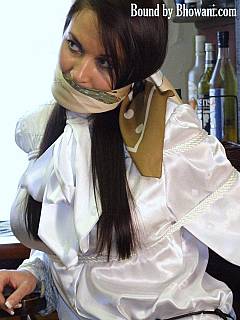 Sexy bondagette is dressed in tight leather pants and having a scarf gag in her mouth