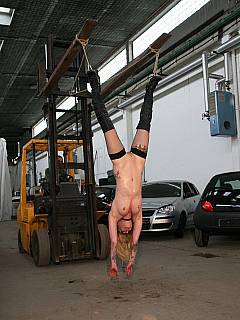 Suspended by her legs on the forklift truck, subjected to corporal punishments