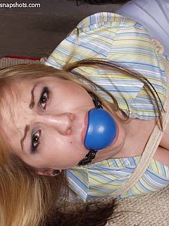 Captive blonde is bound and having an extremely big ball gag in her mouth