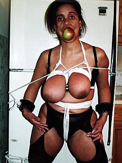 Busty ebony housewife is in captivity, handled by the bondage professional