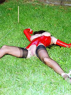 Latex slut is taken to the middle of the lawn and spread eagled there