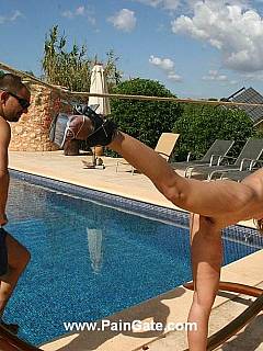 Poolside punishment: slim lady is stretched with bondage ropes and lashed with bullwhip
