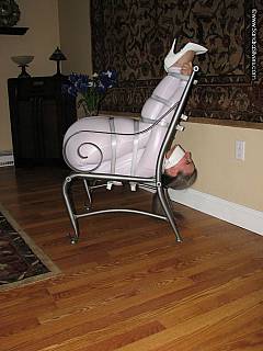 Plumper is derssed up in white PVC suit and ball-tied on the chair