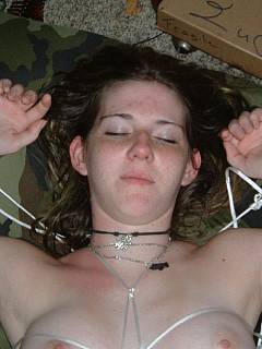 Young slut is greeting her master posing spread-legged and bound in bed