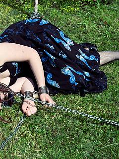 Cuffed girlfriend is left onb the grass with chains connected to her collar
