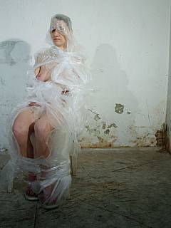 BDSM trainee is wrapped in plastic and whipped until it the tape bursts in pieces