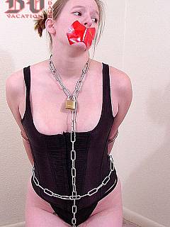 Tape gagged redhead is fully restrained with one chain and three sets of handcuffs