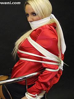 Busty bimbo in red blouse is in bondage and exposing her hot tied up legs