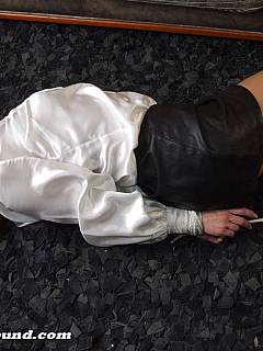Hogtied babe is fighting restraints on the floor: wearing white blouse and her mouth is stuffed with cloth