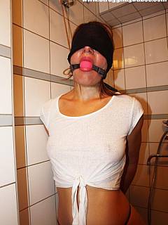 Rope-tied and blindfolded woman is put in the shower: all wet and truing to make sounds with her ball-gagged mouth