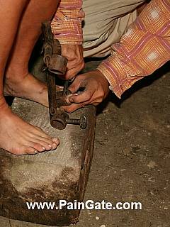 Nde woman is taken to the dark BDSM dungeon, restrained with rusty medieval stocks and then whipped severely