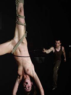Screaming whore is hanging suspended by one leg in this whipping punishments scene