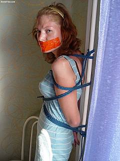 Slim redhead Solana looks very sexy when tied to the steel pipe and unable to speak a word because of the tape gag