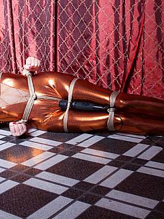 Bondage girl is wearing spandex costume and there is a vibrator in between her legs making her tease sweeter