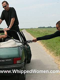 Cheating wife is stretched along the car and whipped by two men in the middle of the field