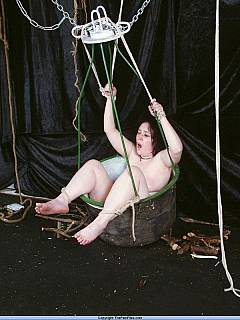 Fat girl is put naked into the big bucket and her bare feet are paddled painfully
