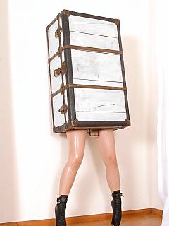 Subgirl is wearing full-body rubber outfit, ballet shoes and having her upper body locked into the box and belted