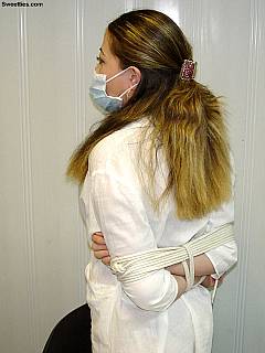 Nurse is still wearing her face mask after somebody tied her up by surprise and unbuttoned white robe