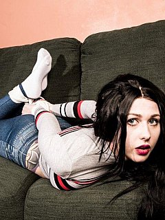 Pretty teen slut stretched and hogtied on top of the sofa in tight blue leggings