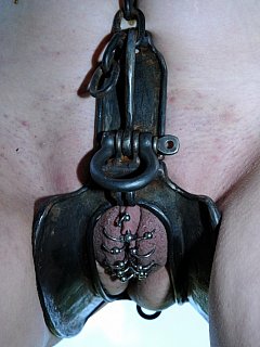 Using slave labor: a girl with the pierced pussy is undressed, put in chains and forced to dig a hole in the ground