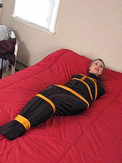 MILF put in black sleepsack and then tied helplessly with yellow ropes
