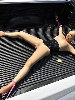 Transporting the tied spread eagle latex doll in the back of a pickup truck