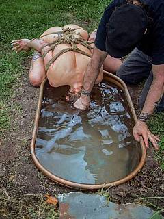 Busty mom is taken for the backyard walk in tight bondage: underwater asphyxiation torture is featured