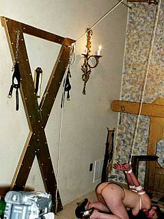 Kneeling amateur is gagged to keep silence while there are clamps being attached to her boobs