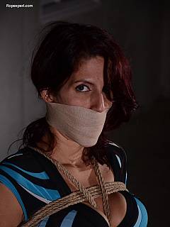 Sexy captive is rope-tied and her mouth is wrapped tightly with cloth so she is remaining completely silent
