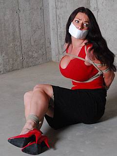 MILF office babe is bandaged and tape gagged: her legs in red high heel shoes are looking veru sexy
