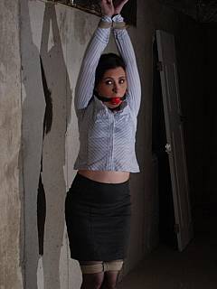 Stretching gagged girl with wrist tie and enjoying her belly visible under the blouse