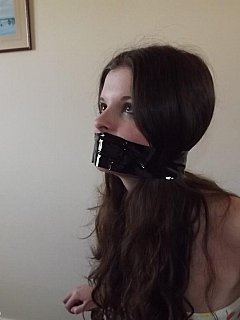 Teeh girl is taped to the chair in front of the mirror where she could see herself helpless